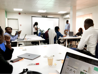 Brainstorming session with product stakeholders — team working around tables with laptops and materials
