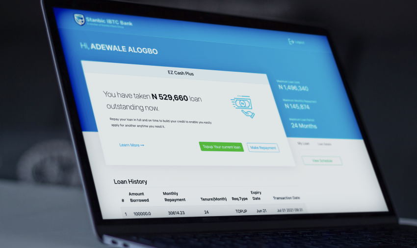EZ Cash Plus dashboard on a laptop — showing loan balance, repayment schedule and loan history for Adewale Alogbo
